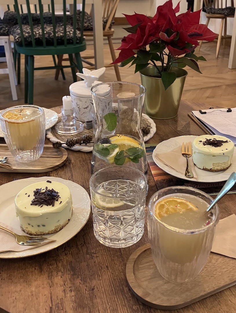 Stolování s cheesecakem, sklenkami citronády a karafou s ovocnou vodou